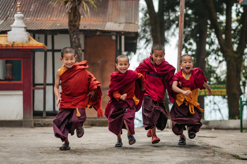 cute children monks running in front of a monaestry