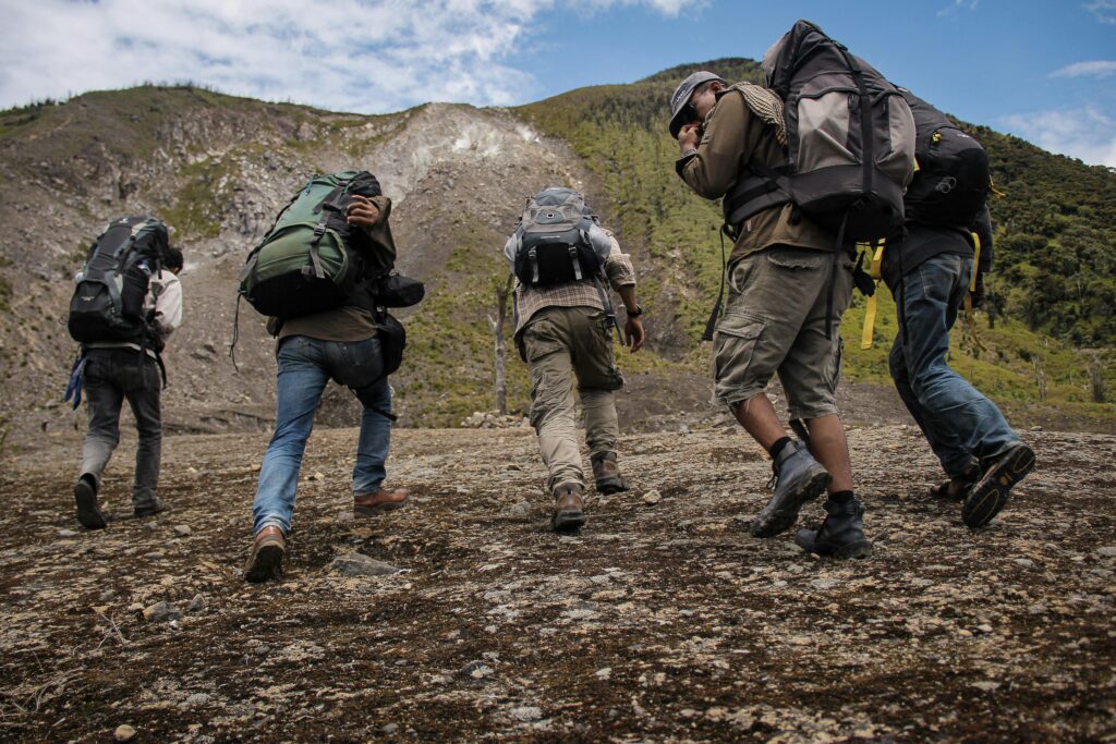 four people on trek climbing a mountain